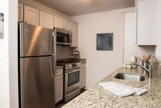 Galley style kitchens with stainless steel appliances, granite countertops and plenty of storage space.